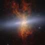 韦伯望远镜拍摄的雪茄星系M82近红外图像，显示密集的蓝色恒星和红色尘埃结构